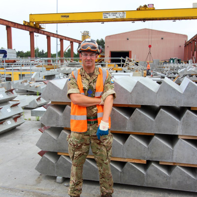 Army reservist Milbank employee poses in front of precast concrete stairs on armed forces day