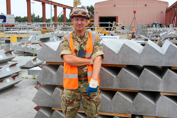 Army reservist Milbank employee poses in front of precast concrete stairs on armed forces day