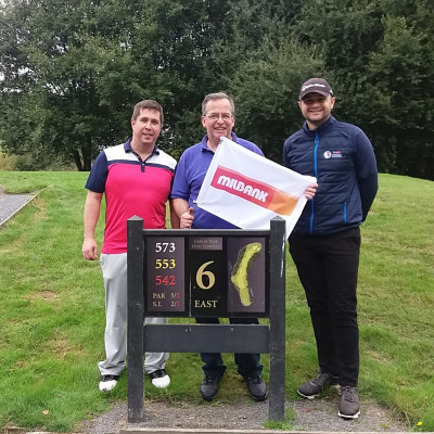 Milbank employees poses with flag at Marlborough Highways Golf competition