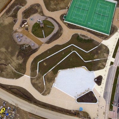 Aerial view of bespoke precast concrete seating units in housing development with tennis courts and play area