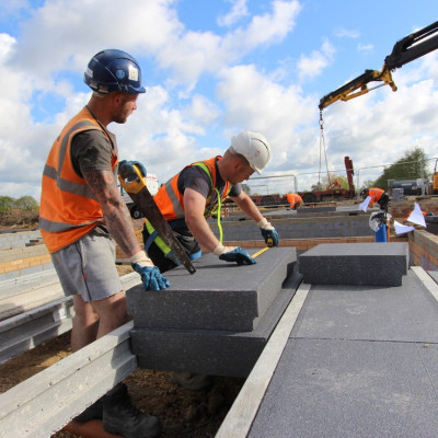 Milbank team cut EPS panels with saw for installation between concrete beams