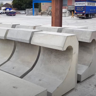 Mark Ellis poses with specialist precast concrete sea defence wave walls in production yard