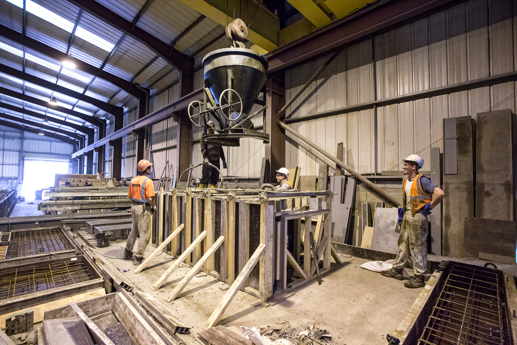 Factory employees managing concrete pour of bespoke mould